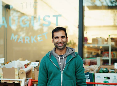 Gogan in front of grocery store he manages