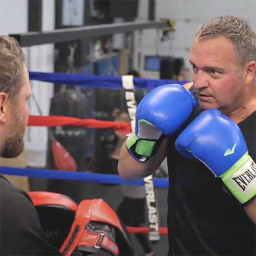 Image of Mick Pariseau boxing with a coach