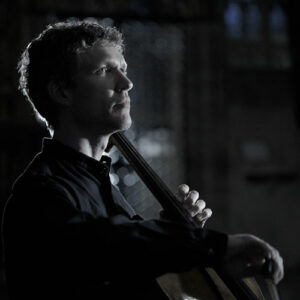 Artistic portrait of Matthew sitting with cello