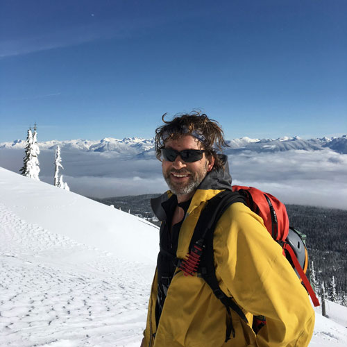 Doug with snowy mountains behind him