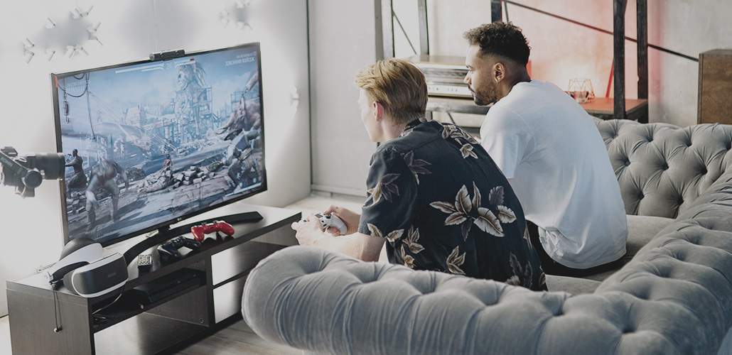 Two guys sitting on a couch playing video games