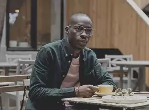 Man wearing glasses, sitting in cafe