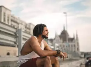 Man in jogging outfit sits and looks into the distance